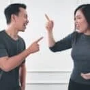 man in gray crew neck long sleeve shirt standing beside woman in black crew neck shirt