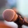 grey microphone on brown wooden stand