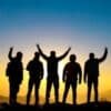 silhouette of people raising their hands