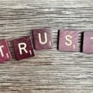 trust spelled with wooden letter blocks on a table